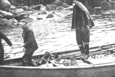 449: J V McCarthy's skiff arriving with a load of fish. J V McCarthy (left). Michael Reddy's  house at center, his father James' house at left, James' shed at right. [courtesy of  Mollie McCarthy]  - J V son of Thomas McCarthy &amp;amp; Anastasia Fitzgerald, married Julia Reddy